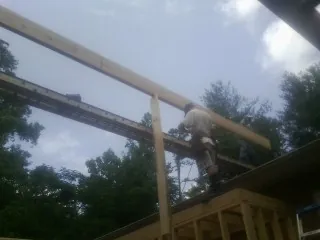 Carpenter setting a ridge beam over a new addition frame — Ice Dam Removal by Roofing Brothers in Palmdale