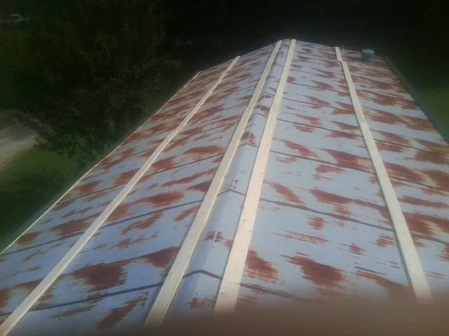 Rusted metal roof panels with new wood purlins before replacement — Storm Damage Roof Repair in Palmdale by Roofing Brothers